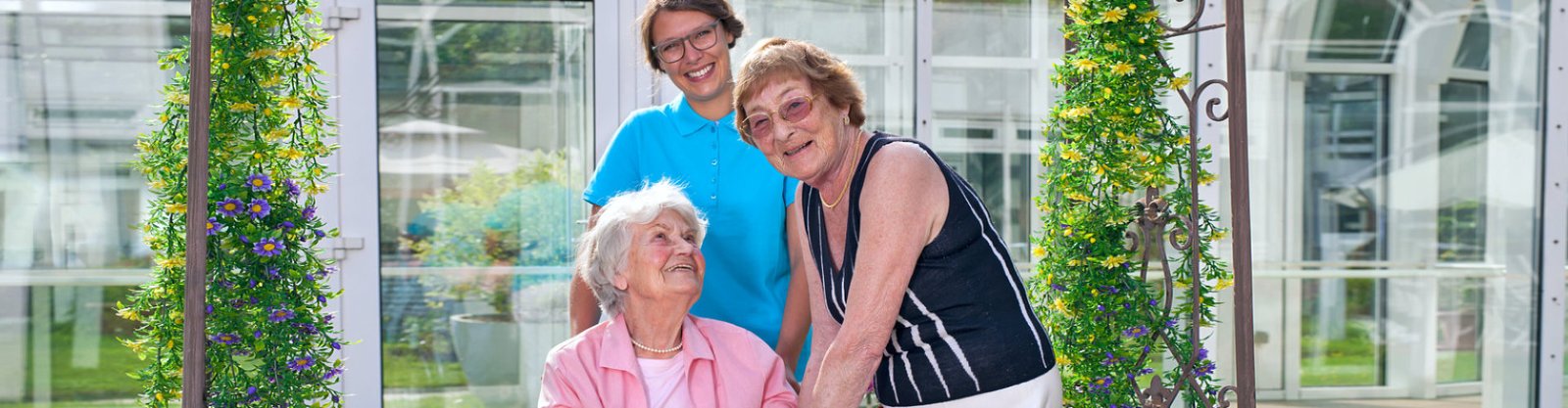 two senior woman smiling with caregiver